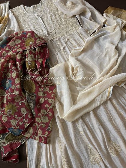 The complete ensemble laid flat, showing the Anarkali with both its matching dupatta and the optional Kalamkari dupatta.