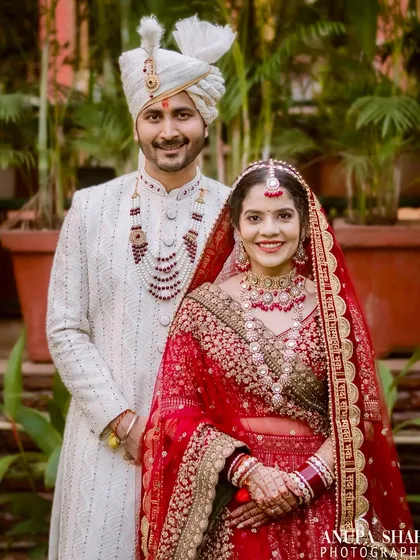 A formal wedding portrait of the couple standing together. This shot captures the elegance of their attire and their poised, happy presence on their special day.