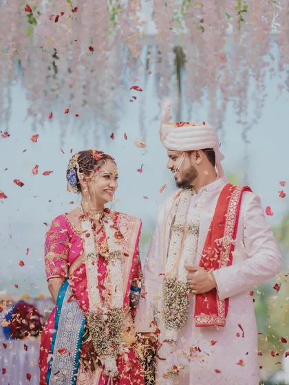 A magical moment under a shower of petals. The bride and groom's happiness is palpable, and her makeup remains flawless throughout the festivities.