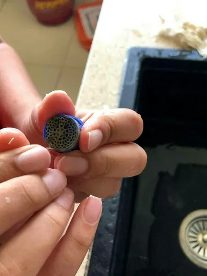 A student learns to clean a faucet aerator, a simple task that makes a big difference. This is part of our plumbing module focused on water conservation.