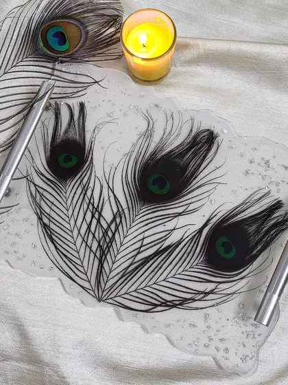 This elegant resin tray was made using real peacock feathers and a sprinkle of silver flakes. It's perfect for holding your favorite perfumes or jewelry and adds a unique touch to any space.