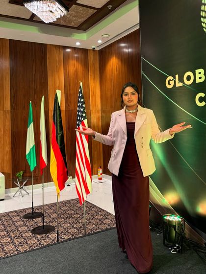 Welcoming delegates to the Global Investment Convention, with flags of participating nations in the background. I am experienced in hosting events with international attendees.