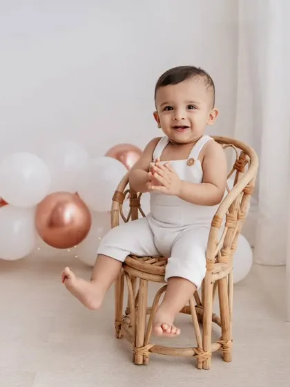 A classic seated portrait for a first birthday. This little one looks so proud sitting in his mini rattan chair, ready to celebrate.