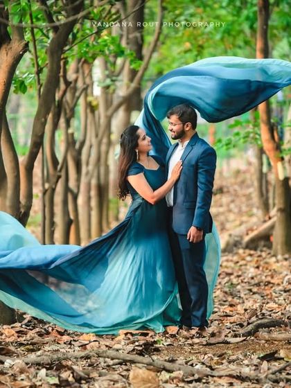 The forest becomes a ballroom in this enchanting shot. The movement of the long, flowing trail of the gown adds a dynamic and whimsical element to this nature-based pre-wedding photo.