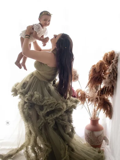 A joyful mother lifting her daughter into the air. This high-key, backlit photo has a dreamy and ethereal feel, full of happiness.