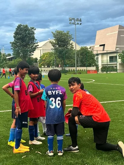 Our AFC-certified coaches are experts at connecting with young children. A coach kneels down to chat with our youngest players, showing the patient, encouraging, and hands-on guidance we provide in every session to build confidence.