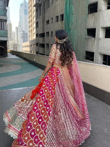 The back view of the half-updo, showing the twirl-worthy lehenga and the beautiful hairstyle.