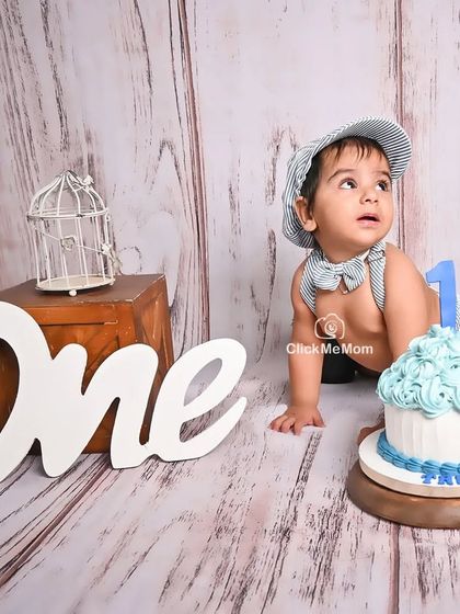 Ready for his close-up. This little boy is crawling towards his first birthday cake in our rustic-themed studio setup, complete with a newsboy cap and bow tie.