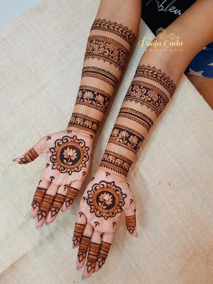 The front view of a unique bridal design with patterned bands. The palms feature a central lotus mandala, which contrasts beautifully with the striped patterns on the arms.