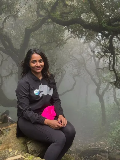 A trekker sitting in the magical, misty forest of Kumara Parvatha.