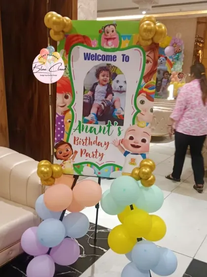 A personalized Cocomelon welcome stand with balloon accents for Anant's birthday party.