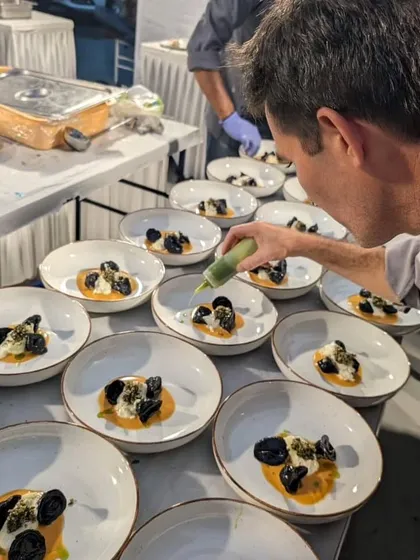 The final touch. A chef adds a drizzle of green oil to our handmade tortellini with organic sunchoke and artisanal burrata, a dish created using seasonal produce from a local organic farm.