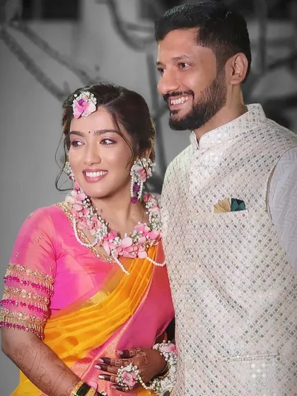 Another shot of the happy couple, showing how the floral jewellery complements the bride's pink and yellow saree.