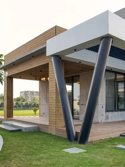 Another view of the distinctive V-shaped columns and the seamless transition from the wooden deck to the surrounding lawn and landscaping.