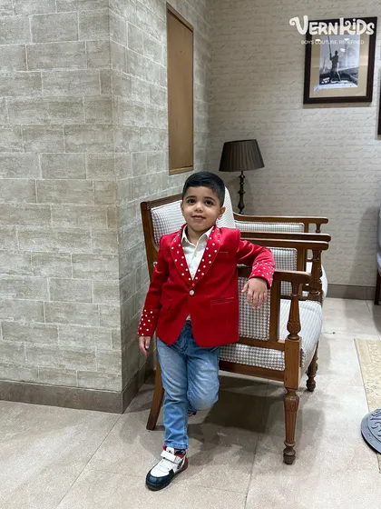 A casual pose in a not-so-casual jacket. The vibrant red velvet and polka-dot details make this a standout piece for any occasion.