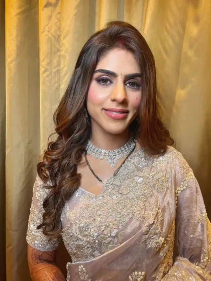 A full look at this beautiful reception outfit, with makeup that perfectly complements the soft, elegant tones of her saree.