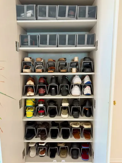 This full view of a shoe cabinet shows how we combine different organizing tools, like stackers for shoes and bins for accessories, to create a comprehensive storage solution.