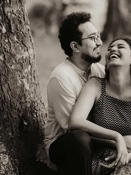 A timeless black and white photograph capturing a moment of pure, uninhibited laughter between Anjum and Soham. This style strips away distractions and focuses purely on the emotion and connection between two people.