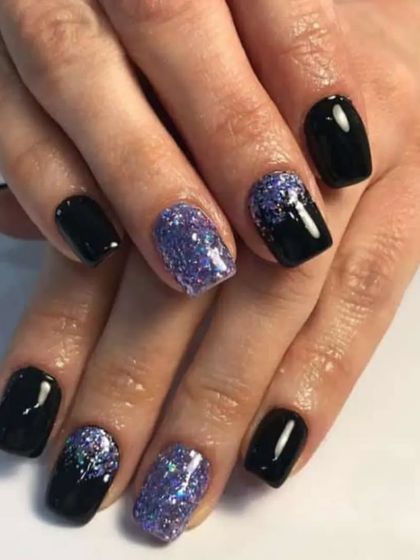 A bold look combining glossy black nails with sparkling purple glitter accent nails on a square shape.