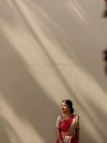 A bride posing against a wall with beautiful, casting shadows. The natural light creates an artistic and serene mood.