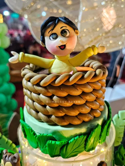 The birthday boy's figurine, popping out of a woven basket on top of the cake.