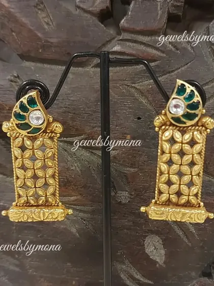 A pair of Dakshinaya earrings with a green enamel top and intricate gold lattice work. These pieces are lightweight yet make a statement, perfect for long hours of celebration.