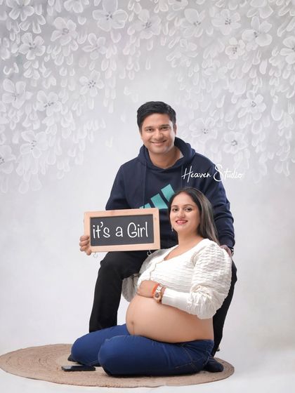 Announcing their joy to the world. This happy couple shares their "It's a Girl" news in a relaxed and casual studio setting, a perfect way to remember this exciting milestone.