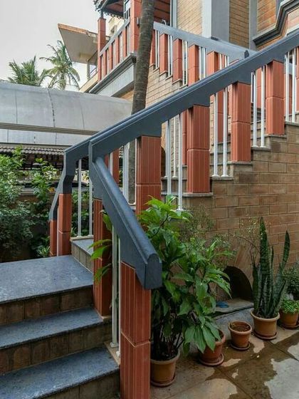 The entrance to this Bangalore home is designed as a gradual transition from the outside in. The staircase is flanked by greenery, and the use of exposed brick and stone creates a warm, earthy welcome.