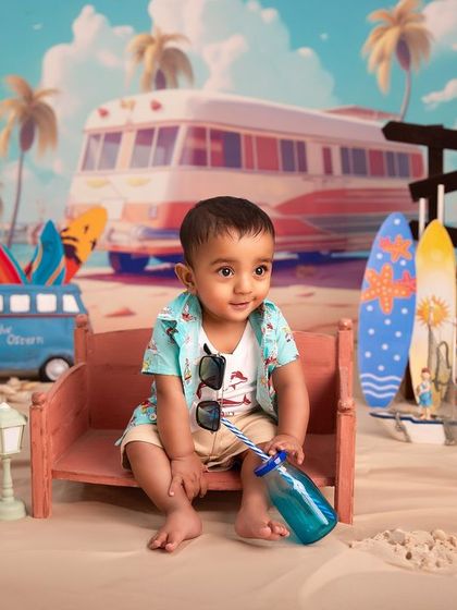 Soaking up the studio sun. This toddler is enjoying a cool drink on a bench in our detailed beach setup, a perfect way to have a summer vacation photo any time of year.