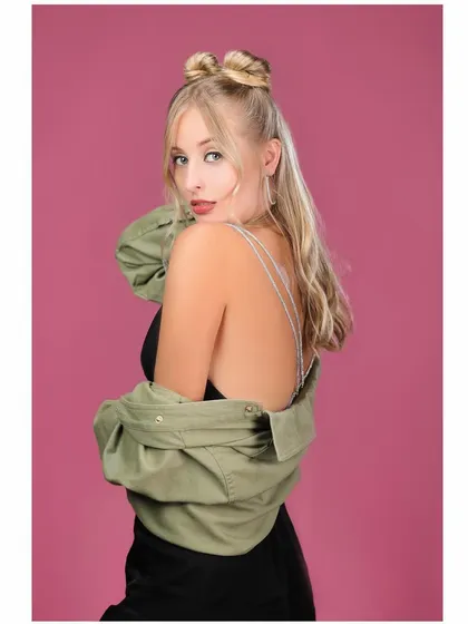 A back-shot from the same series, highlighting the open-back top and hairstyle.