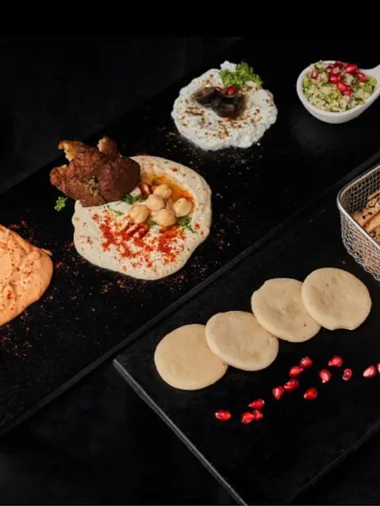 Come taste the difference! Our exquisite Mezze platter features a variety of hummus, falafel, labneh, and fresh pita, all beautifully arranged.
