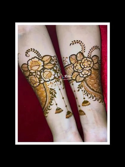 A close-up of the arm portion, highlighting the detailed floral work and the charming jhumki motifs.