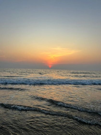 A serene shot of the waves and the sunset over the Arabian Sea.