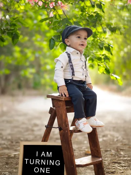 "I am turning one!" This outdoor portrait with a simple sign is a classic and adorable way to announce a first birthday.