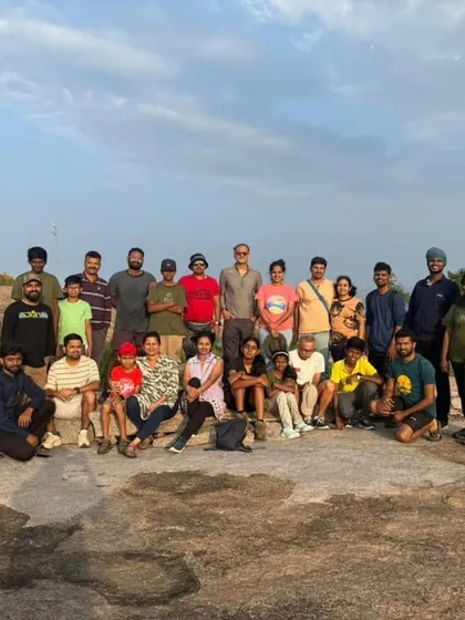 The entire group posing for a photo at sunrise on Minchukallu Betta. It's a shared experience of witnessing a new day begin.