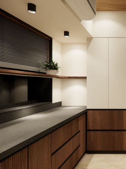 A clean and modern pantry space from our 'Home of Stories' project. The design features minimalist white cabinetry paired with warm wood drawers and a dark countertop, demonstrating our skill in creating functional residential spaces.
