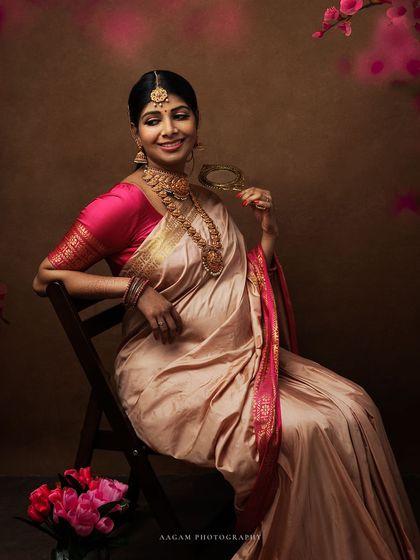 A beautiful portrait in a traditional silk saree, holding a mirror that reflects her own glowing image. It's a celebration of a woman's identity as she becomes a mother.