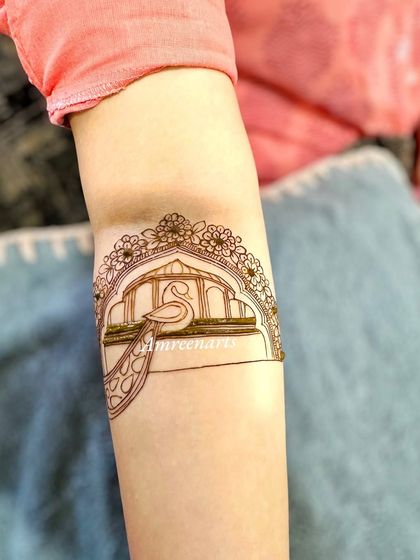 A simple yet elegant arm band with a peacock in a floral arch.