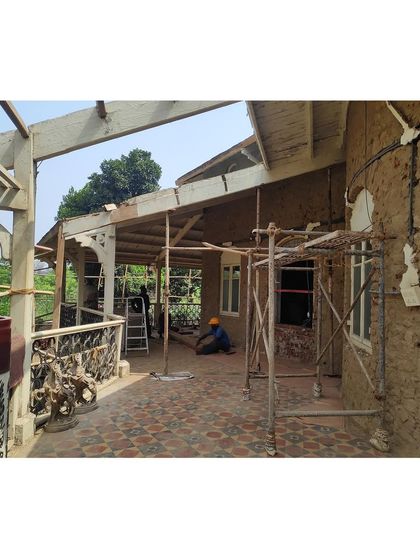 The veranda mid-restoration, showcasing the new flooring being laid and the roof structure taking shape. This phase requires a delicate balance of new construction and integration with the existing historic elements.
