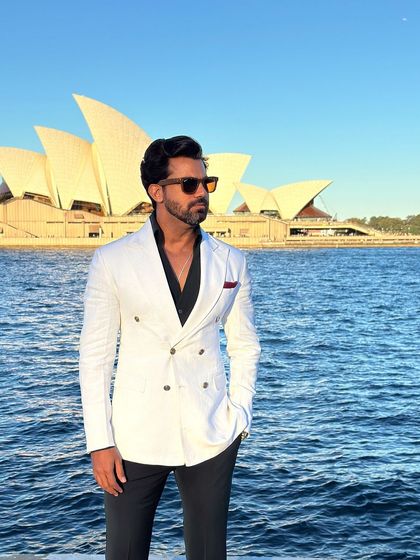 A confident pose in our white double-breasted blazer, a versatile piece for any summer event.