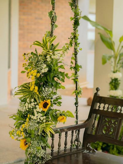 A simple wooden swing becomes a romantic photo spot with the right floral touch. I used a lush arrangement of sunflowers, baby's breath, and cascading greenery to create a dreamy corner at this South Indian wedding.