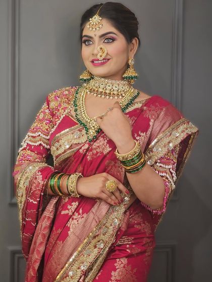 A beautiful bride in a pink Paithani saree. The makeup is bright and festive, with a focus on glowing skin and eyes that sparkle.