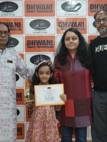 A student with her parents and our senior guru, celebrating her award.