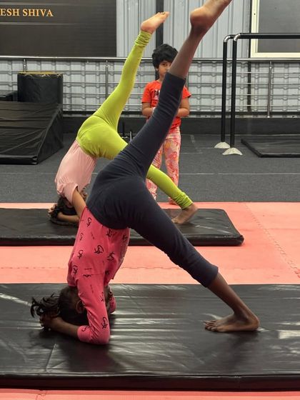 Students practice their headstand splits, a great drill for improving both balance and flexibility.