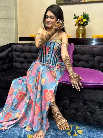 A full-length shot of the bride, showcasing her hand and feet mehandi. A complete and stunning bridal look.