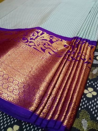 A close-up of the pallu pleats on a light-colored saree. I ensure both the skirt and pallu pleats are perfectly ironed and set.
