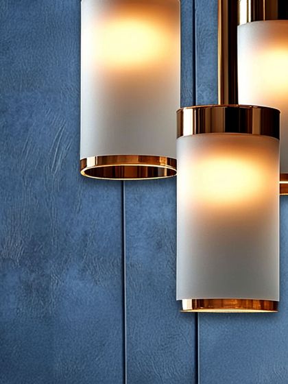 A close-up of modern cylindrical pendants with frosted glass and a metallic trim. The soft, diffused light is perfect for creating a serene and sophisticated atmosphere.