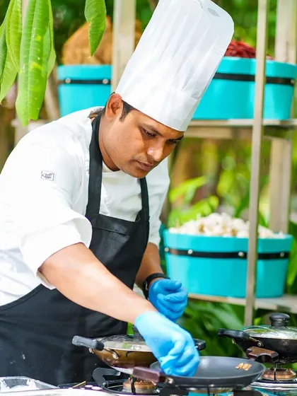 A chef in action at a live cooking station during our anniversary brunch, preparing fresh dishes for our guests.