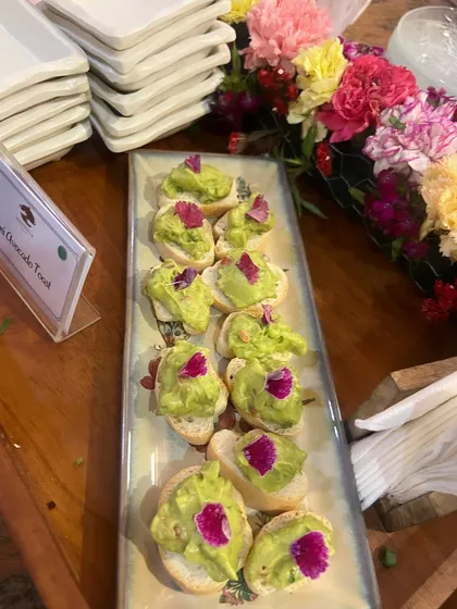 Mini avocado toast on crisp, toasted baguettes. We use fresh, creamy avocado mash and garnish with edible flowers, making it a simple, elegant, and healthy option for any gathering.