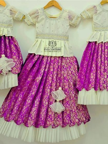 A beautiful set of three matching Banarasi lehengas in white and purple, created for three sisters to wear at a family function.